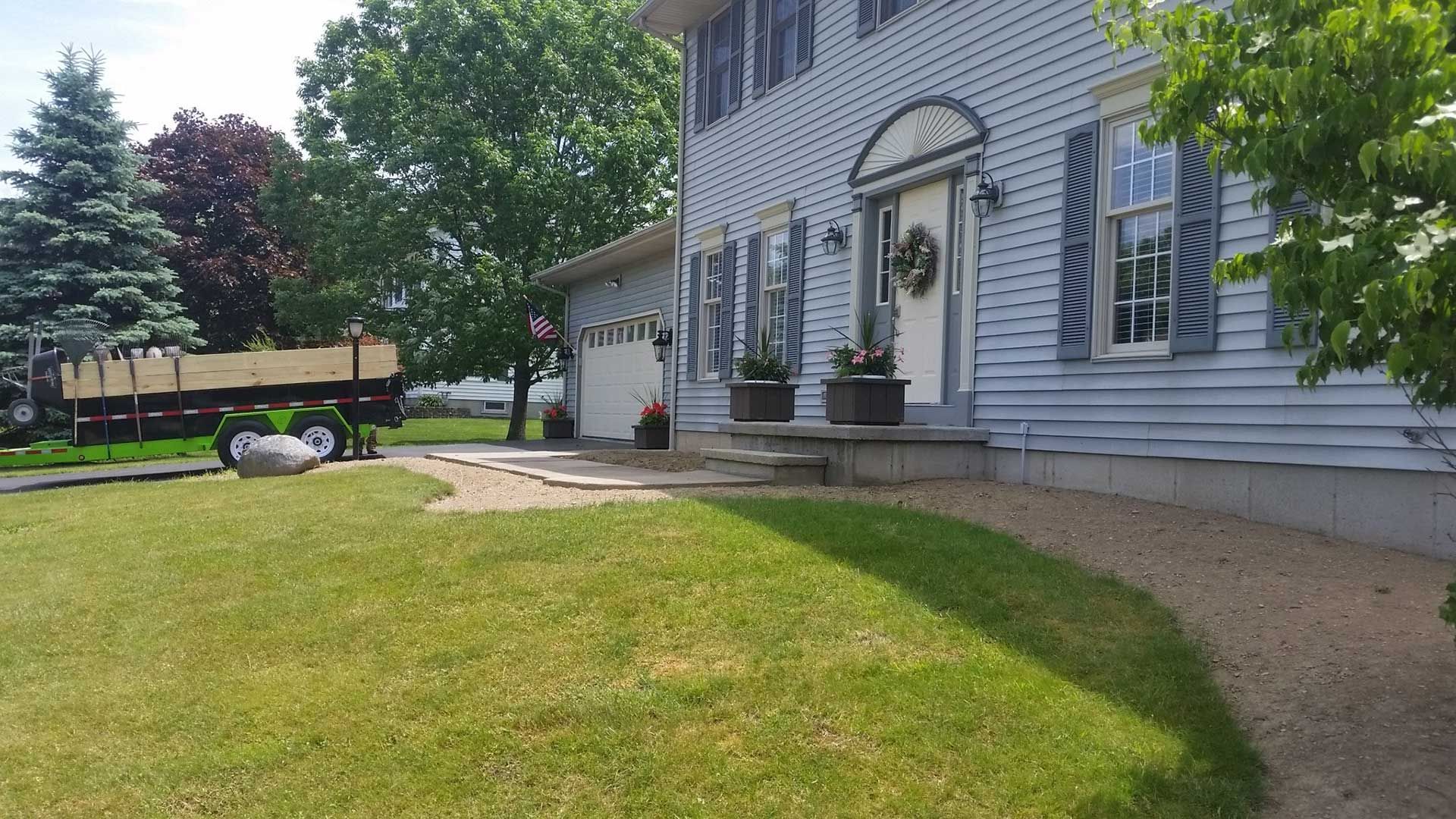 empty flowerbed in front of blue house