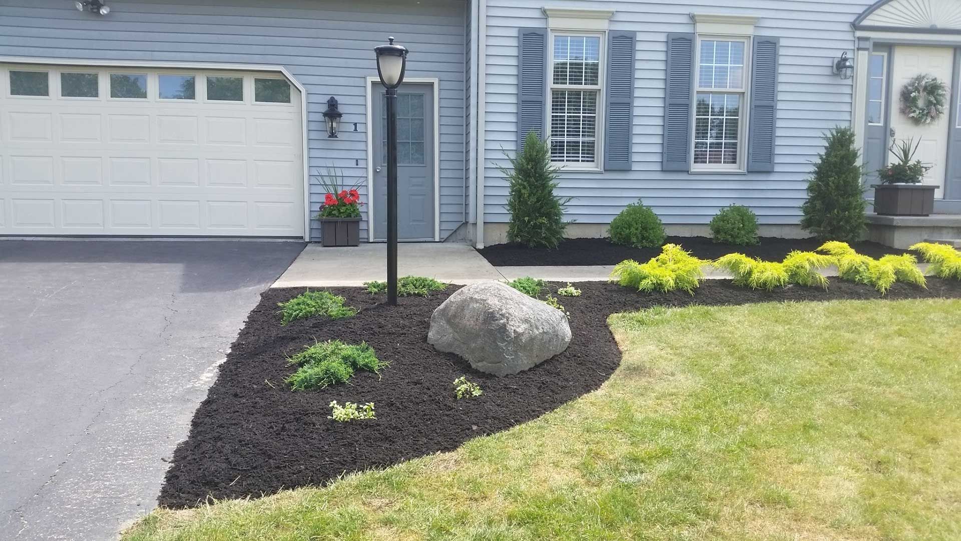 street light and flowerbed in front of house