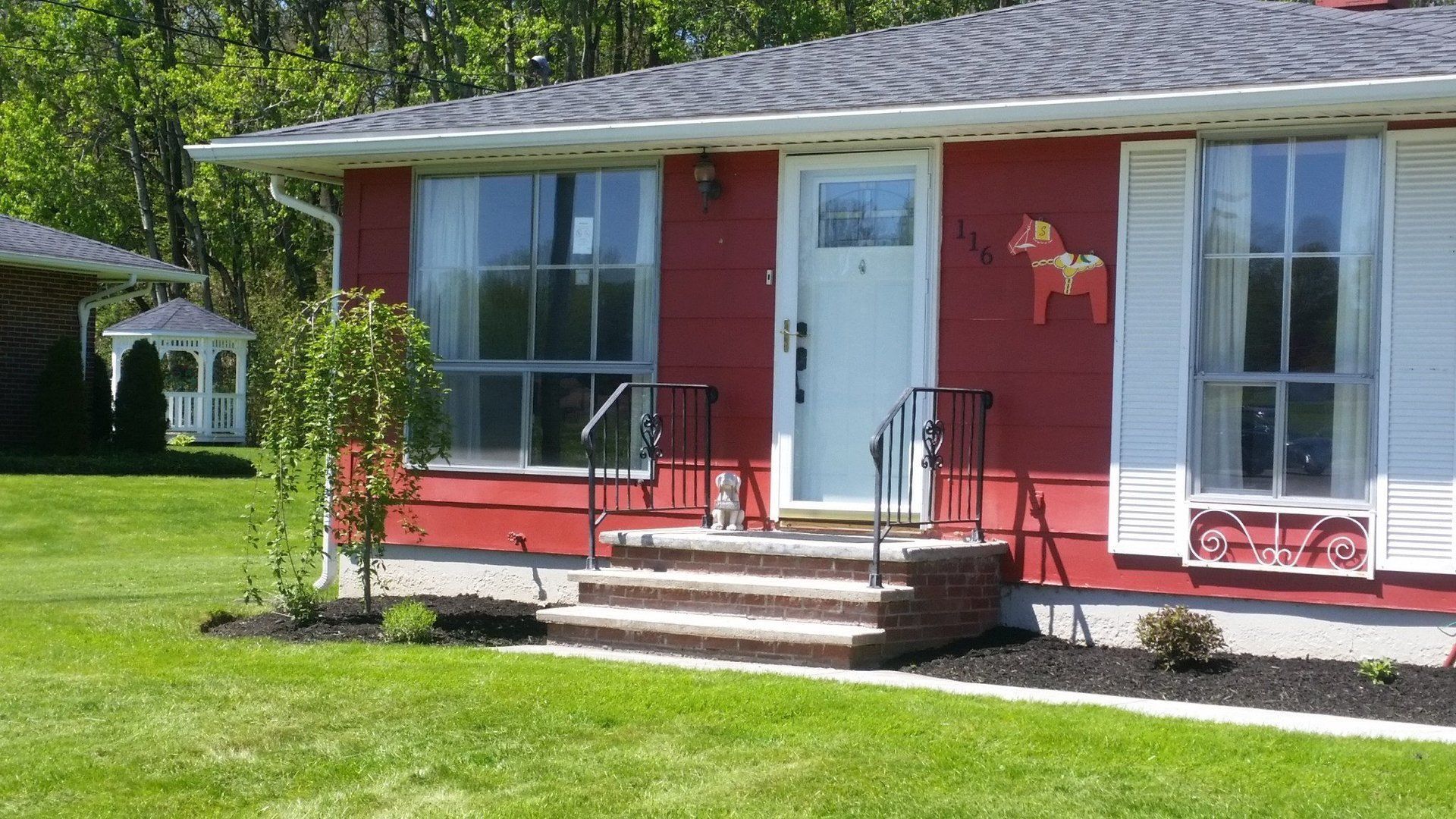new landscaping in front of red house