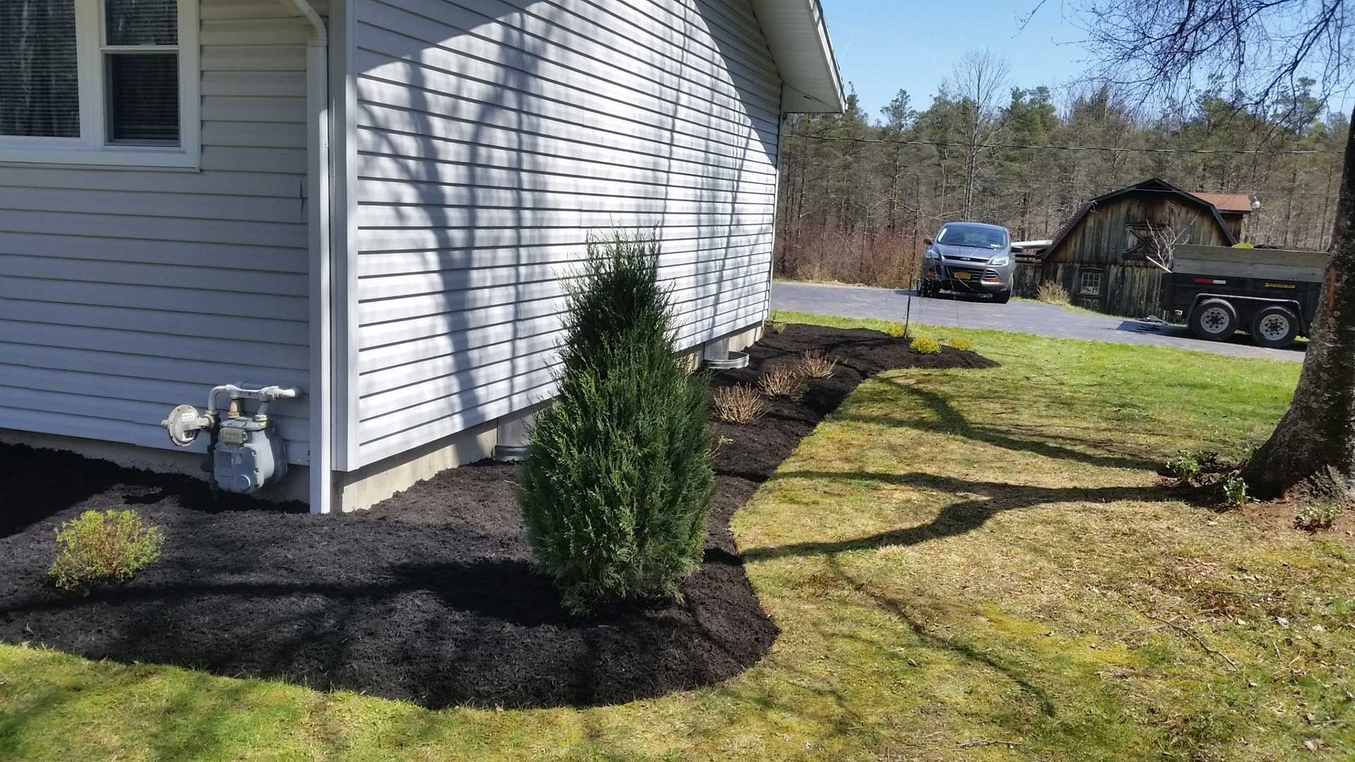 side of house with fresh black mulch and shrubs