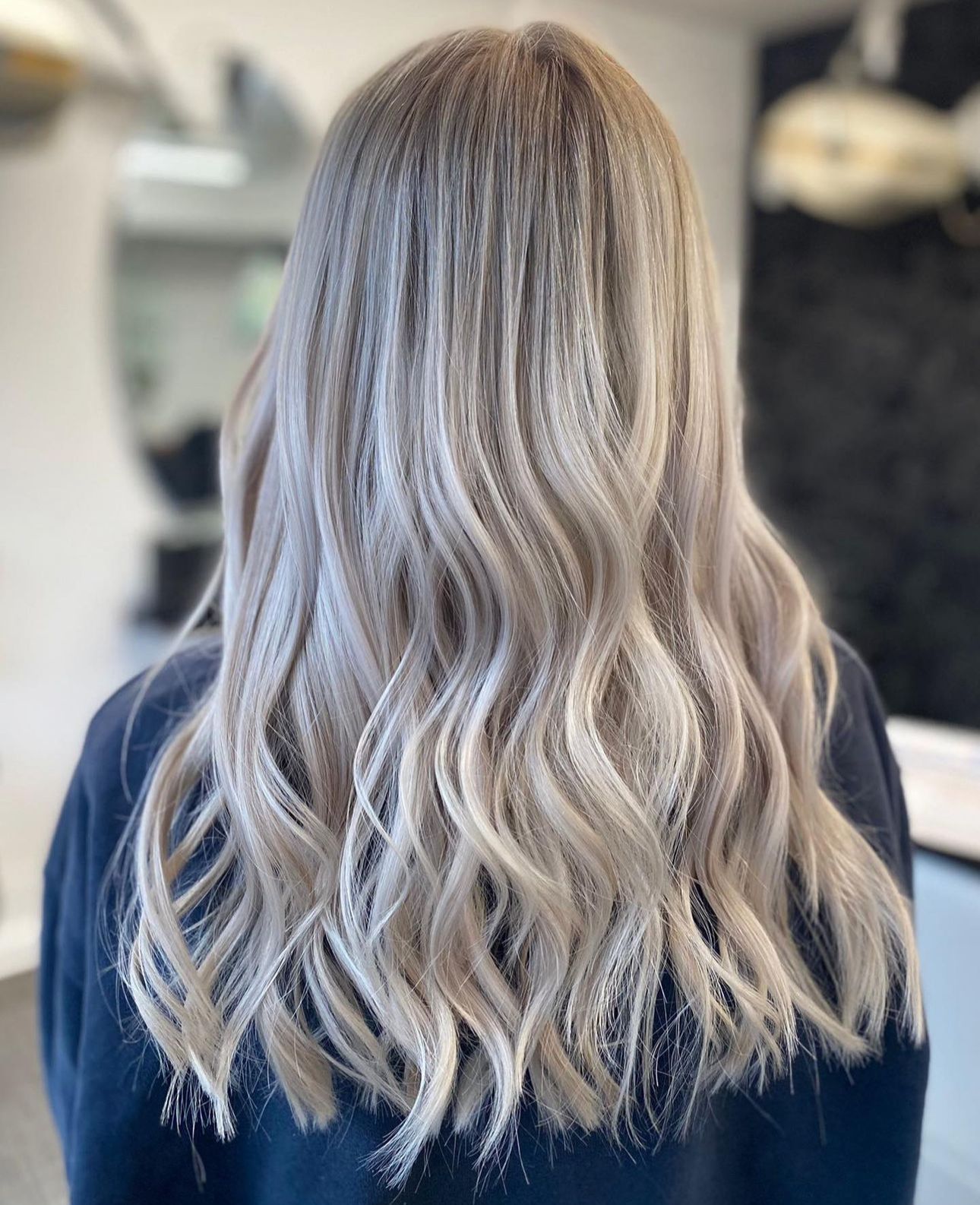 A woman with long blonde hair has had her hair curled at panache 