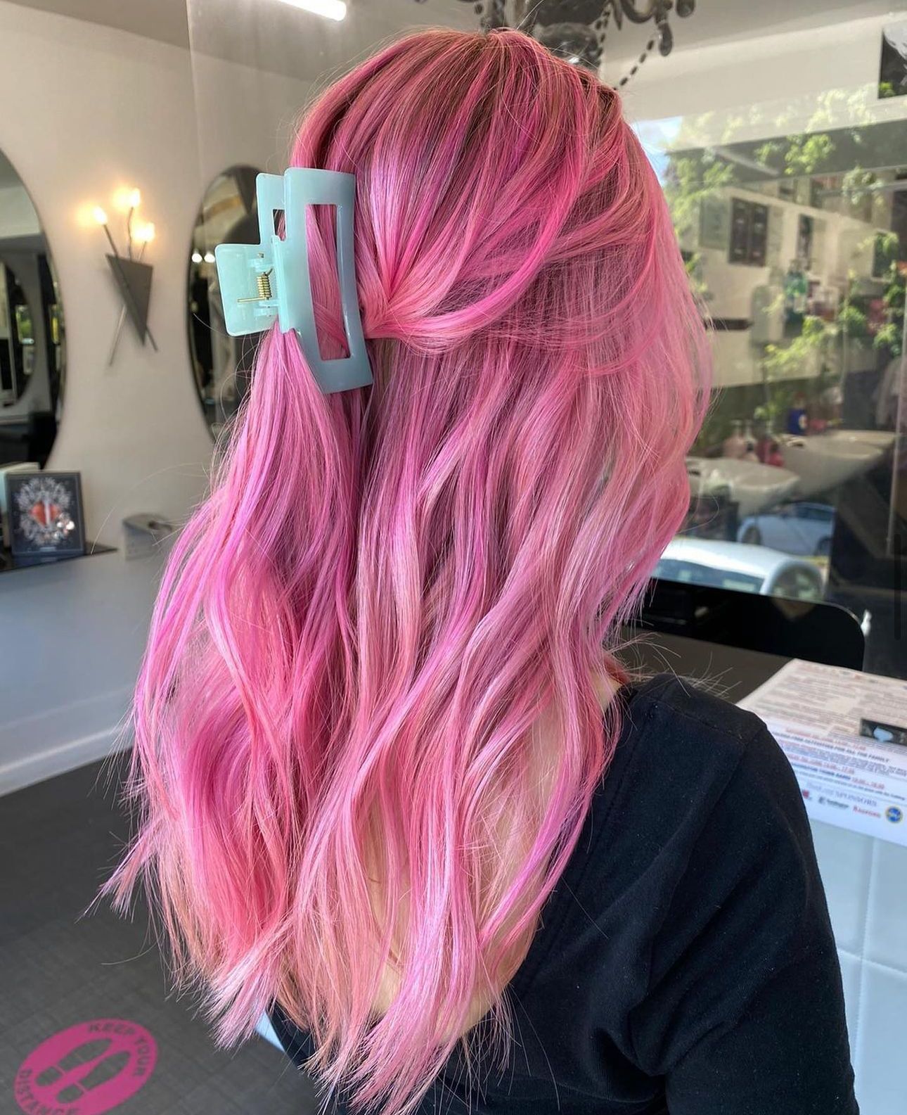A woman with pink hair has had her hair professionally coloured at a hair salon
