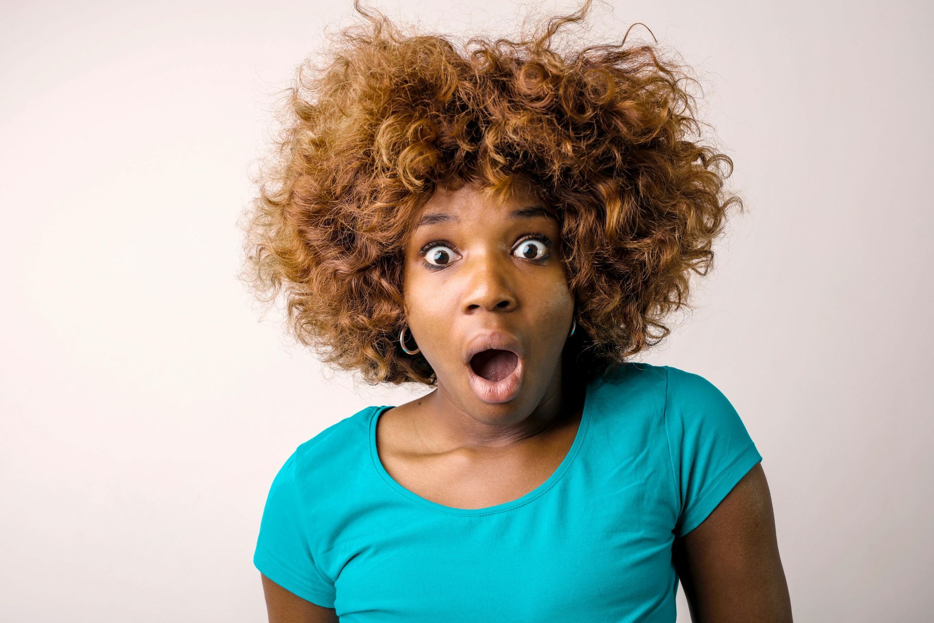 A woman with messy hair wondering if you should visit a hair salon