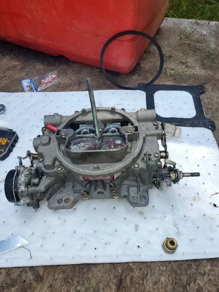 A carburetor is sitting on top of a white mat.