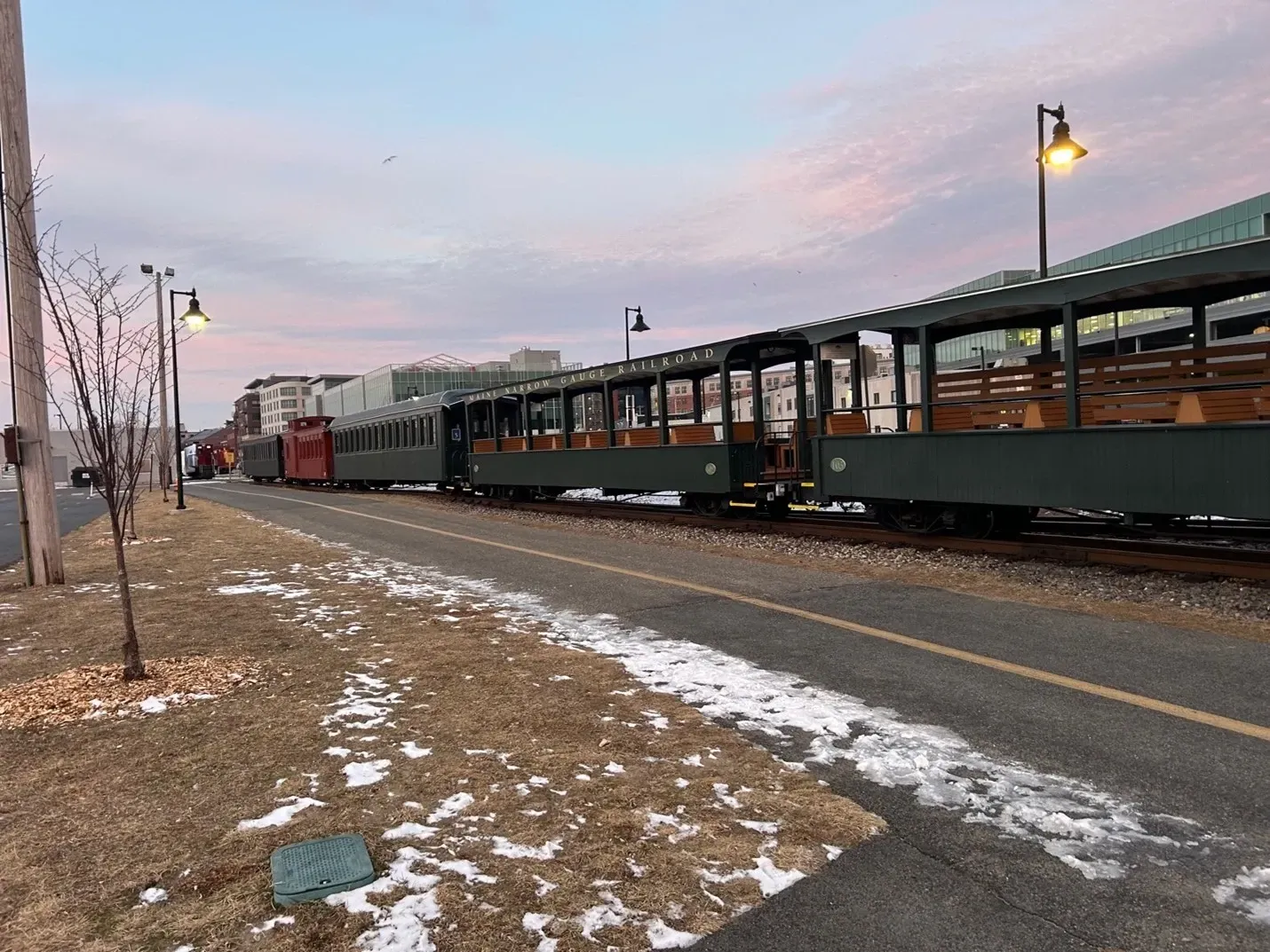 A train is pulling into a train station on a snowy day.
