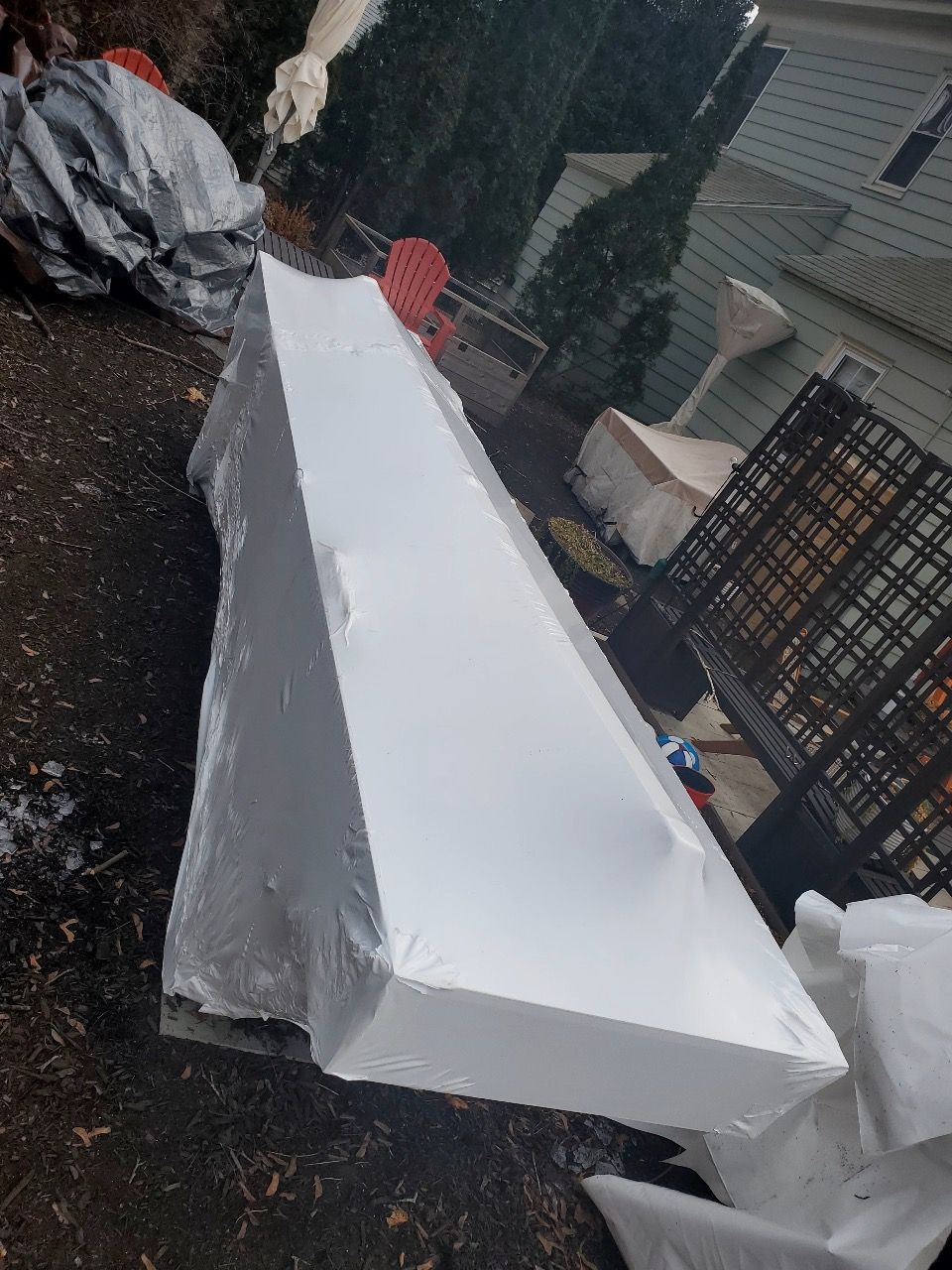A large piece of styrofoam is sitting on the ground.