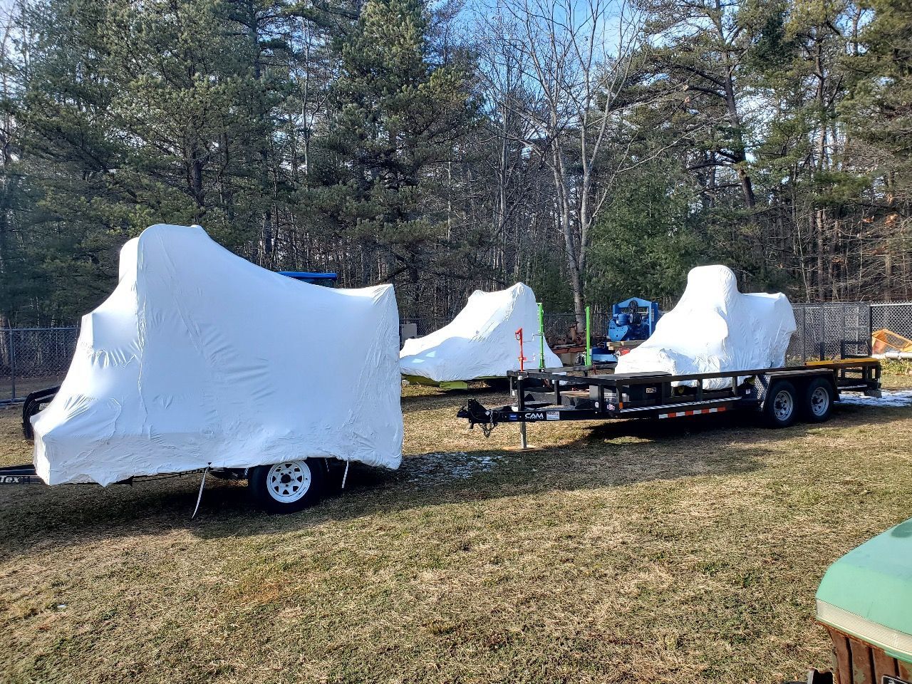 Two motorcycles are wrapped in white foam on a trailer.