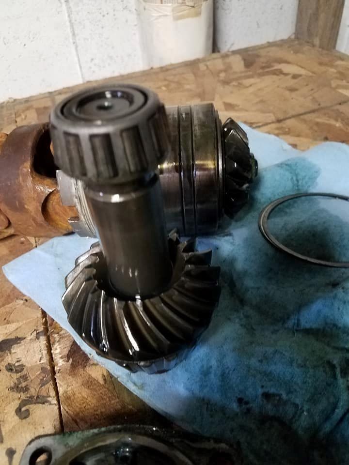 A gear is sitting on a blue cloth on a wooden table.