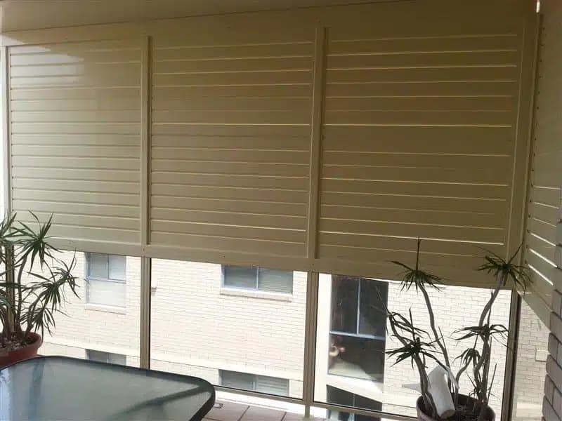 A balcony with a table and a potted plant Aluminium Manufacturer in Newcastle, NSW