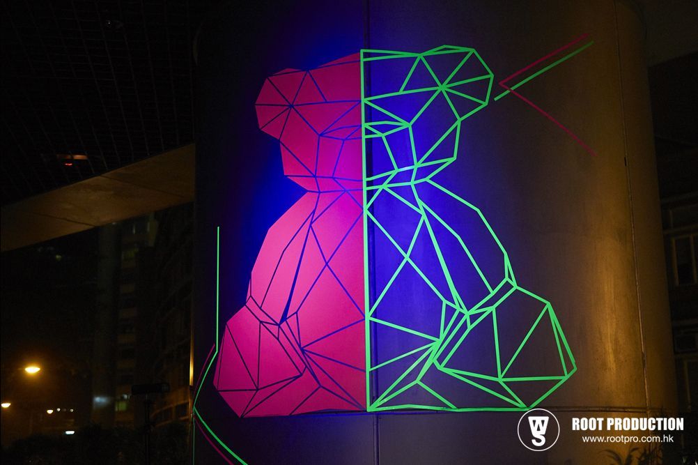 A split image of a teddy bear. Left side is pink, right is green, both outlined with angular neon lines.