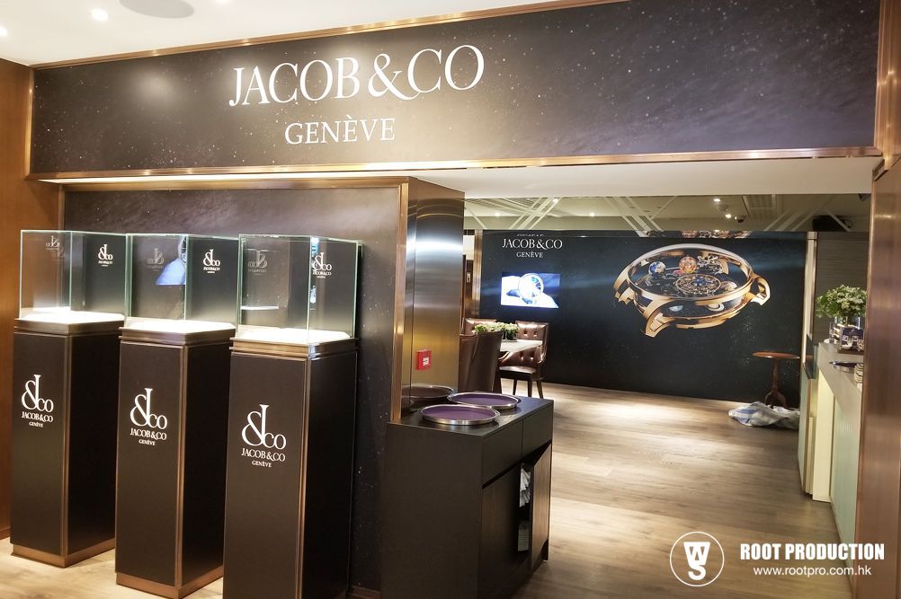 Jacob & Co. Geneva store entrance with display cases of jewelry on pedestals. Dark colors, luxurious setting.