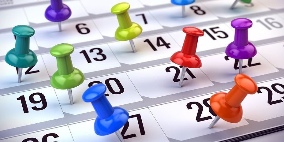Symbolfoto von Terminen. In Prinzip ein Monatskalender mit farbigen Pins an verschiedenen Tagen reingestochen.