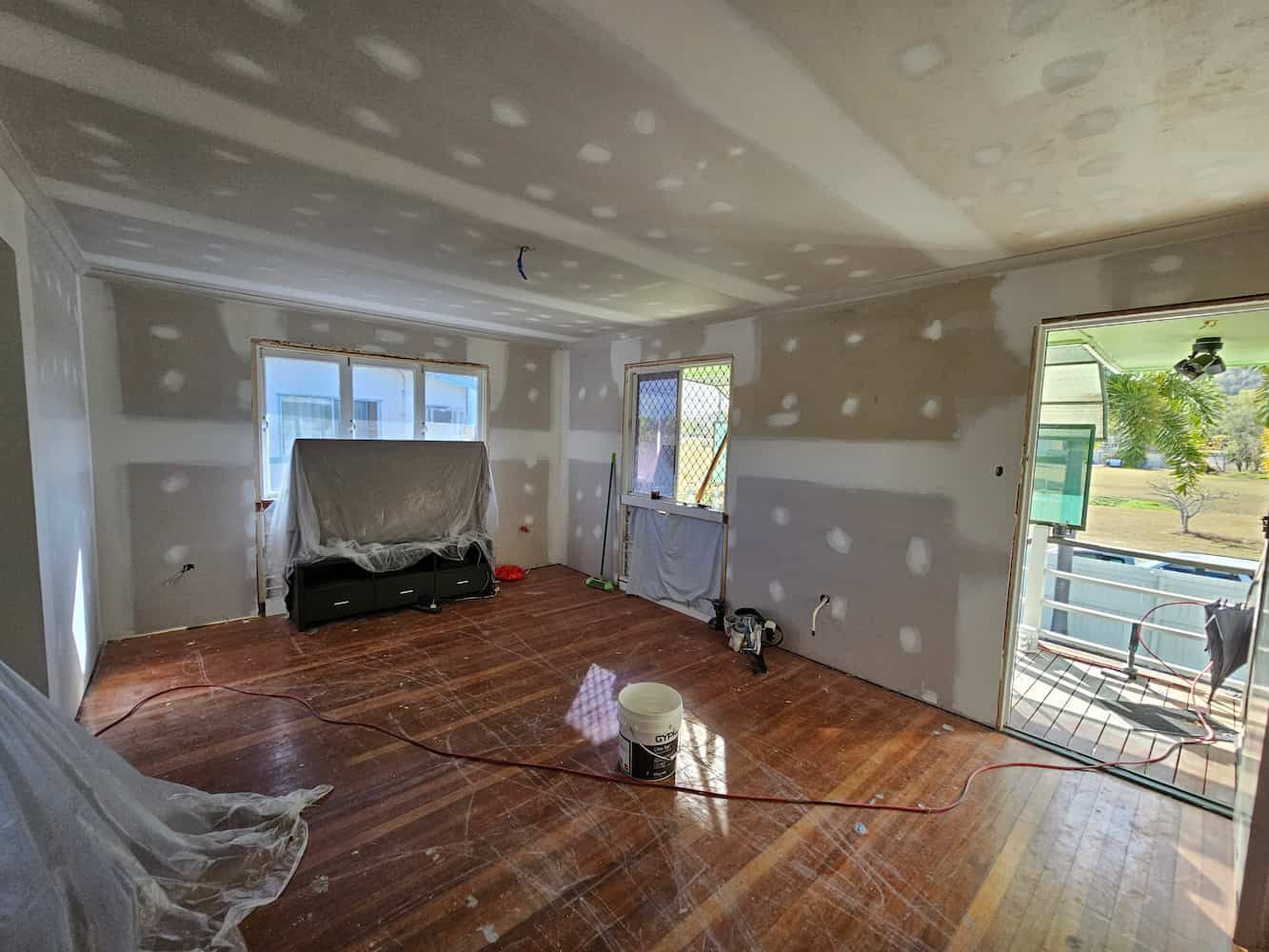 A Living Room With a Wooden Floor and a Couch in It — Poljak Plasterers in Kirwan, QLD