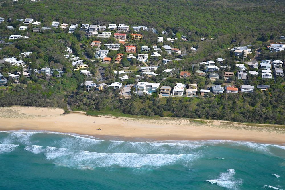 An Aerial View of a Beach and a Residential Area — Poljak Plasterers in Bushland Beach, QLD