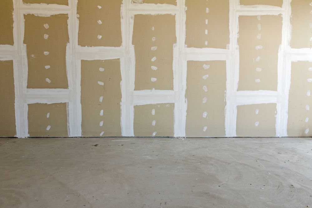 An Empty Room With a Drywall Wall and a Concrete Floor — Poljak Plasterers in Mount Louisa, QLD