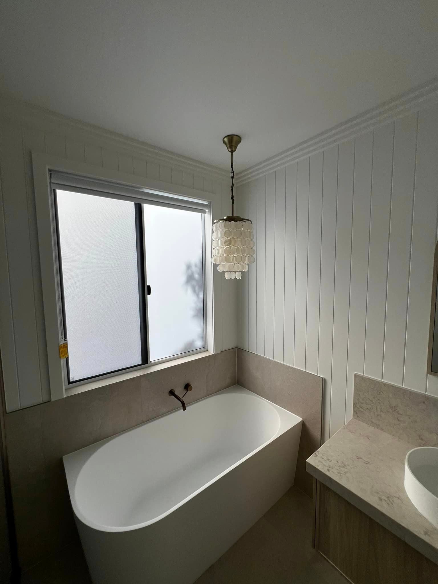 A Bathroom With a Bathtub, Sink, and Window — Poljak Plasterers in Townsville City, QLD