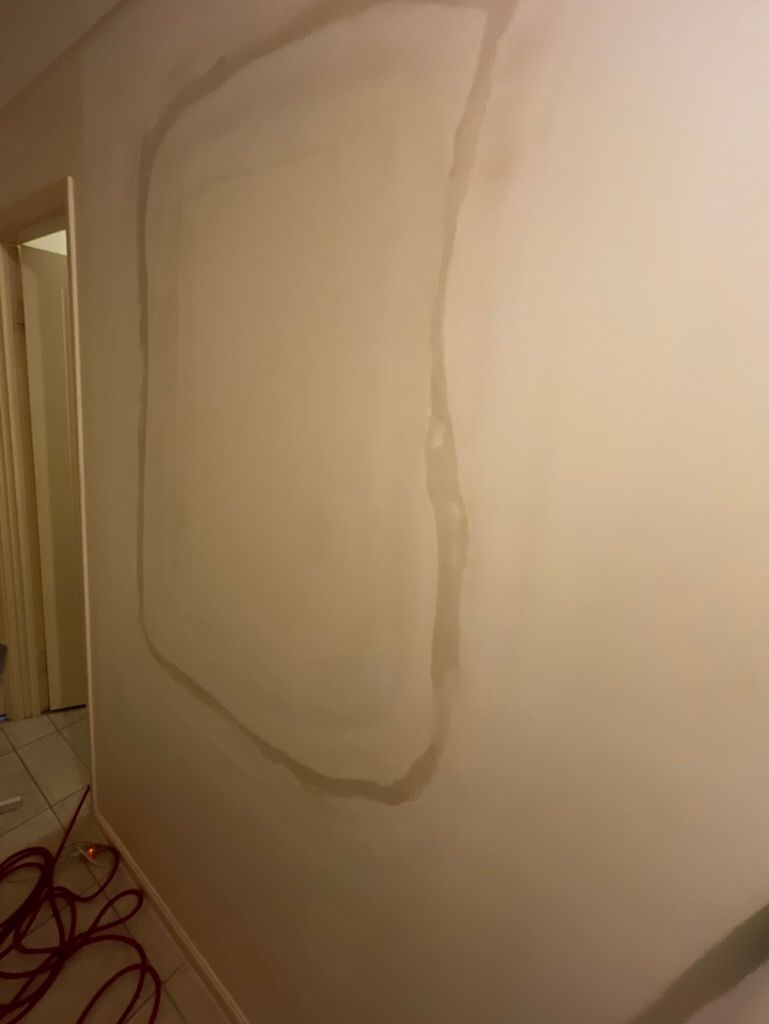 A white wall with a shadow of a person on it