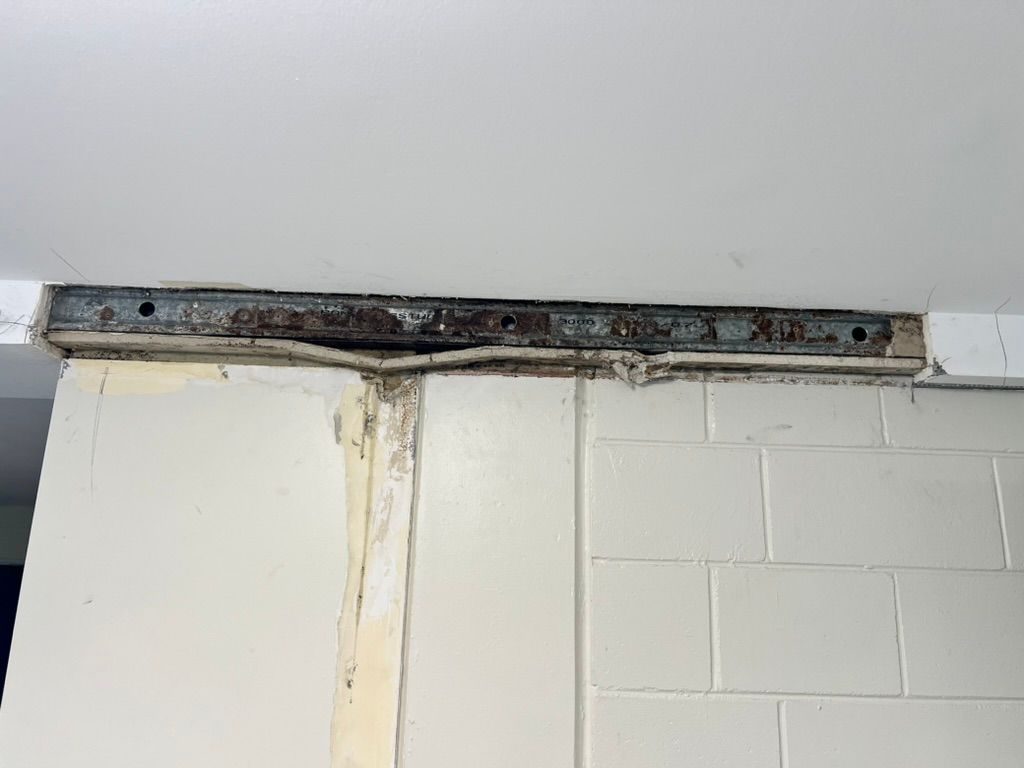 A Man is Plastering a Wall With a Trowel — Poljak Plasterers in Rosslea, QLD