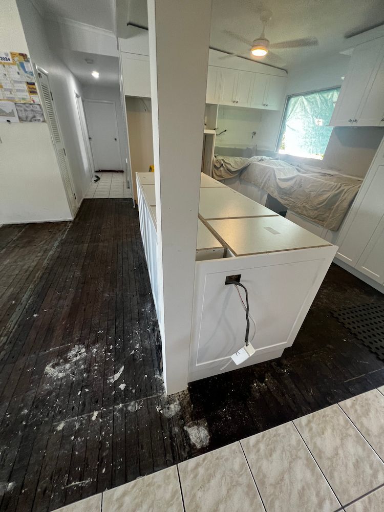 A Kitchen With a Lot of Cabinets and a Ceiling Fan — Poljak Plasterers in Bushland Bach, QLD