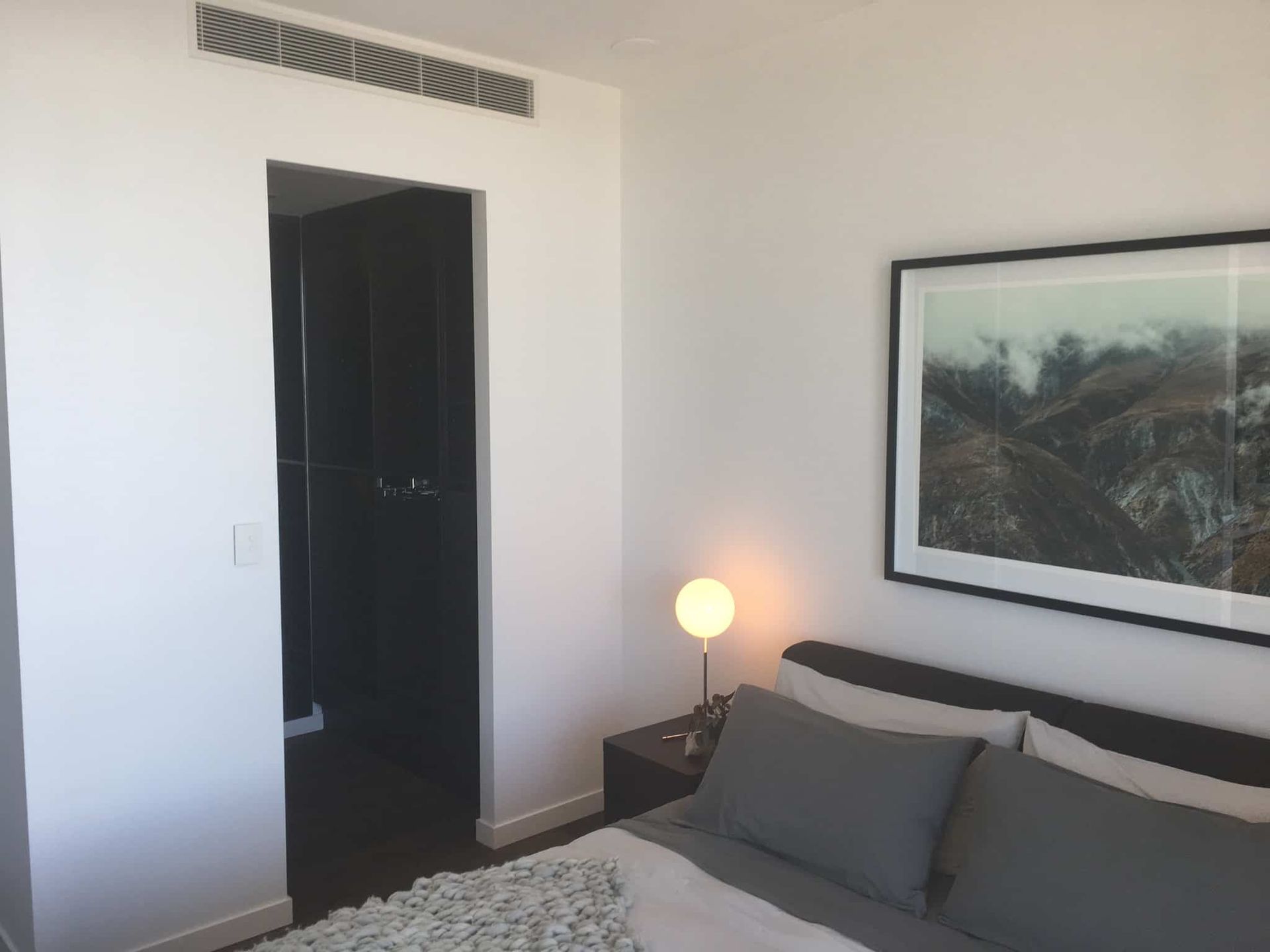 A Bedroom With a Bed and a Picture on the Wall — Poljak Plasterers in Rosslea, QLD