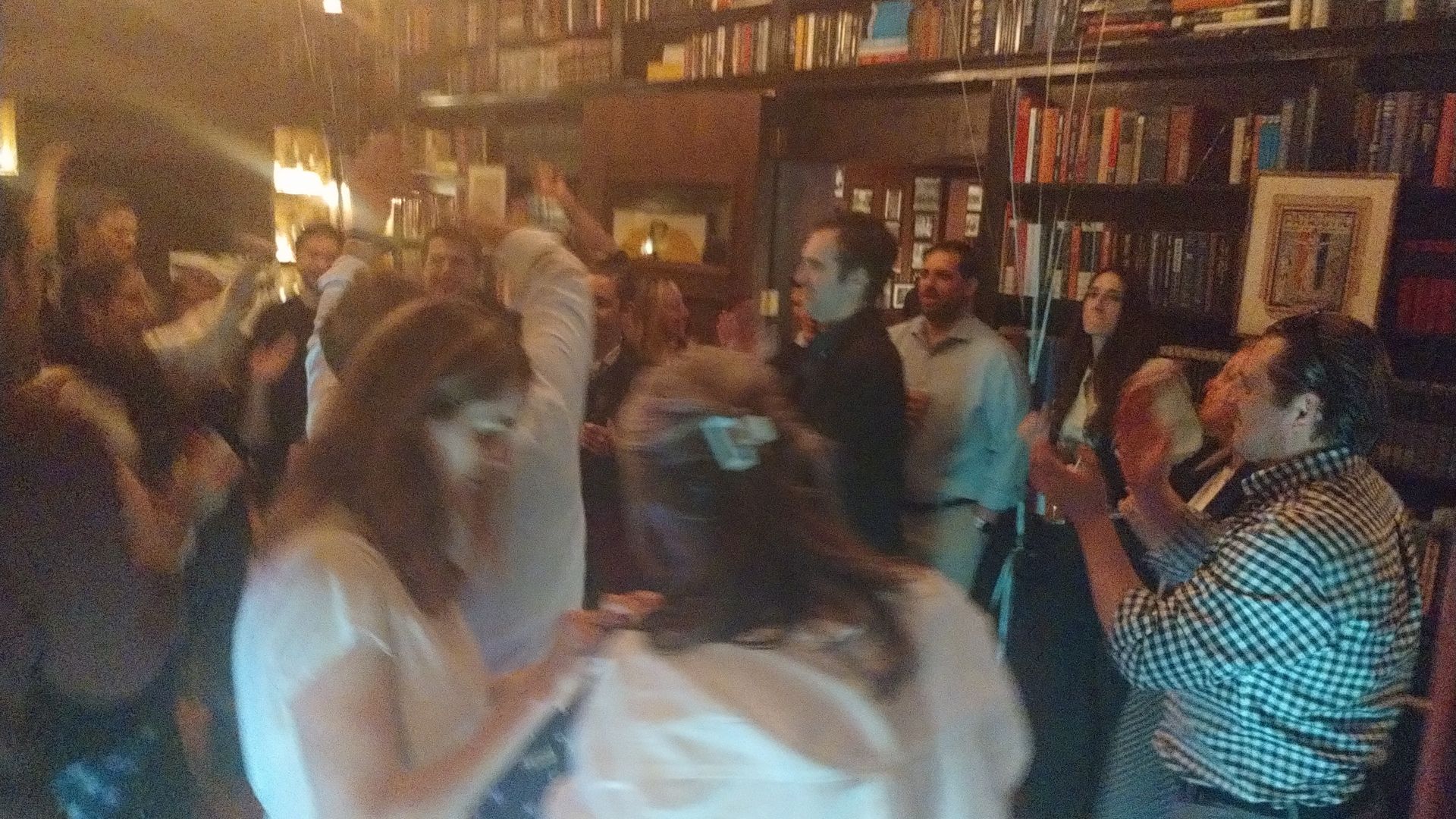A group of people are dancing in a dark room.