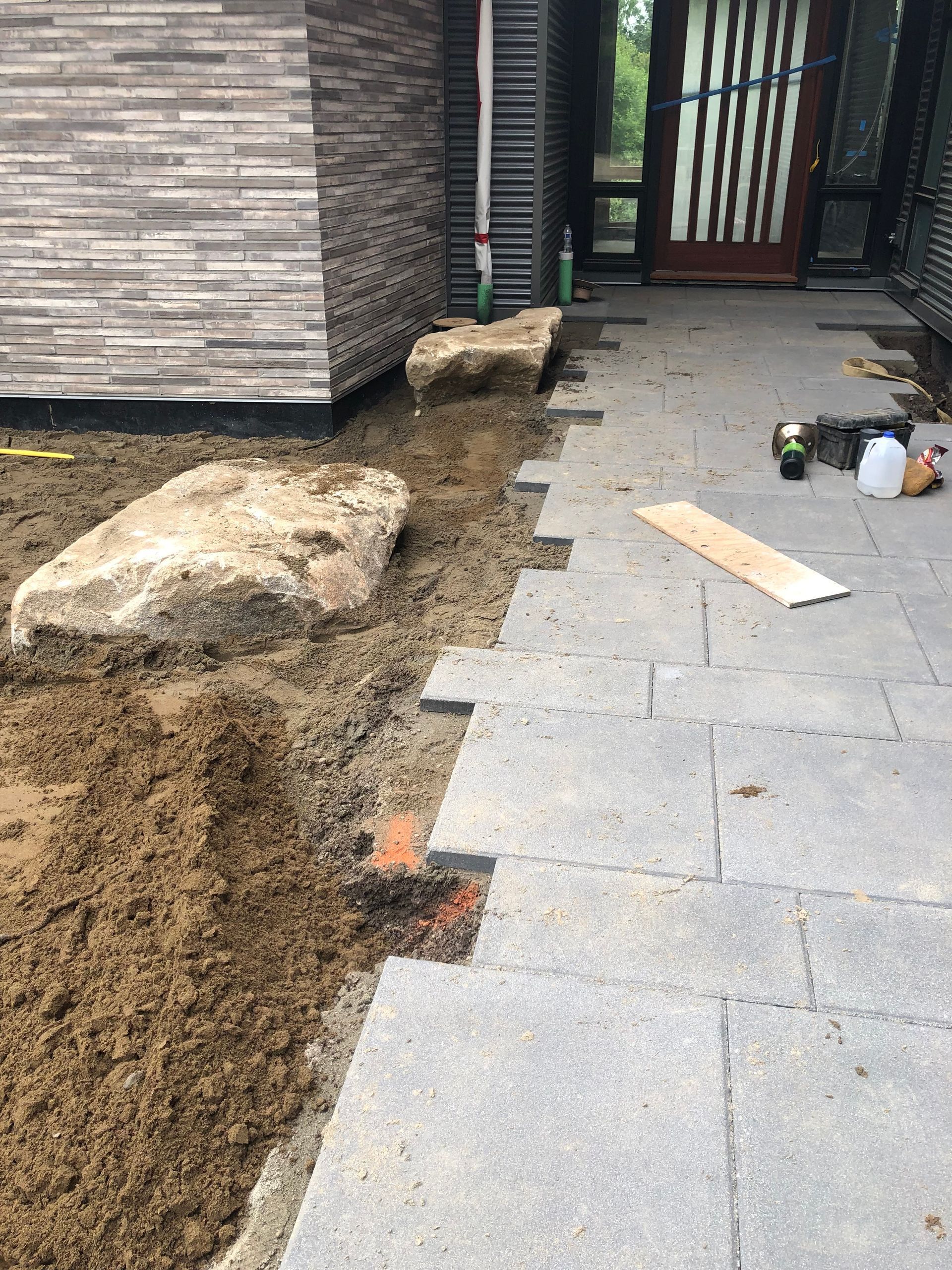 Pathway construction: soil trench next to stone pavers.