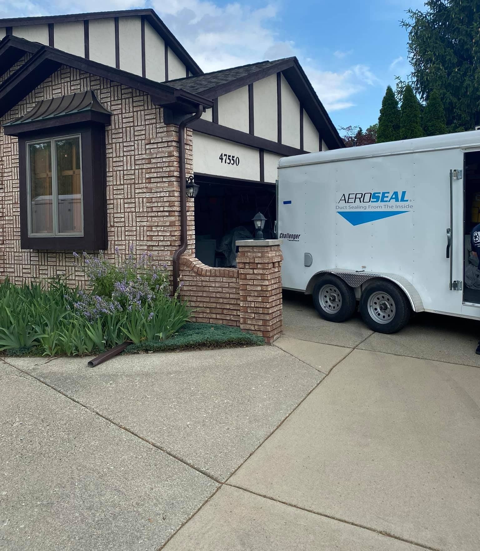 A montreal trailer is parked in front of a house