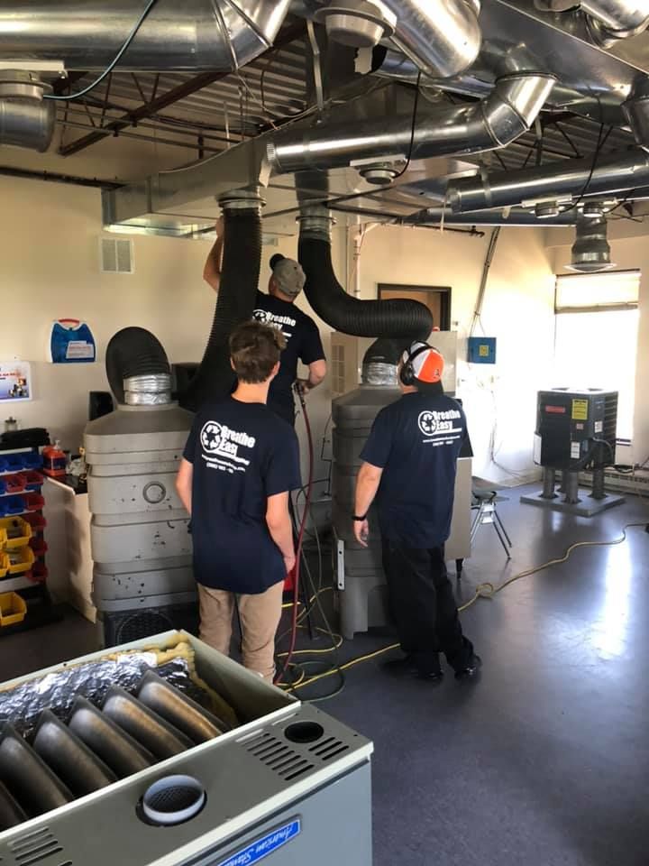 A group of people are working on a machine in a room.