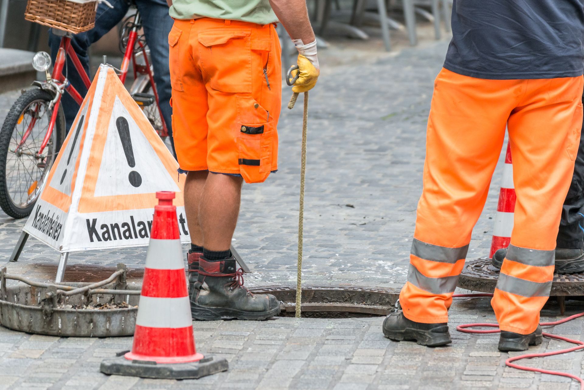 eine Gruppe von Arbeitern steht neben einem Kanalschild