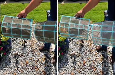 Person handling wire mesh cages over gravel in a garden bed