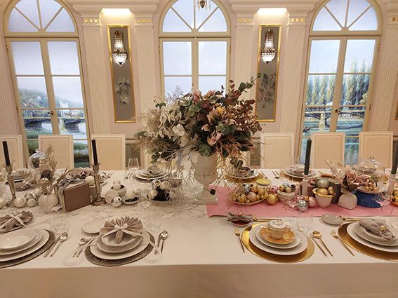 Weihnachtlich eingedeckte Dinnertische, edles KPM Porzellan, goldenes Besteck, üppige Tischaufsätze mit Blumen
