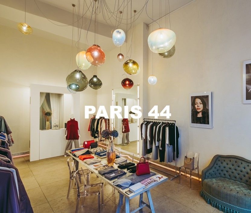 Location Paris 44.  Mischung aus Wohnzimmer und Kleiderboutique. Bunte Leuchten an der Decke, Bilder an der Wand