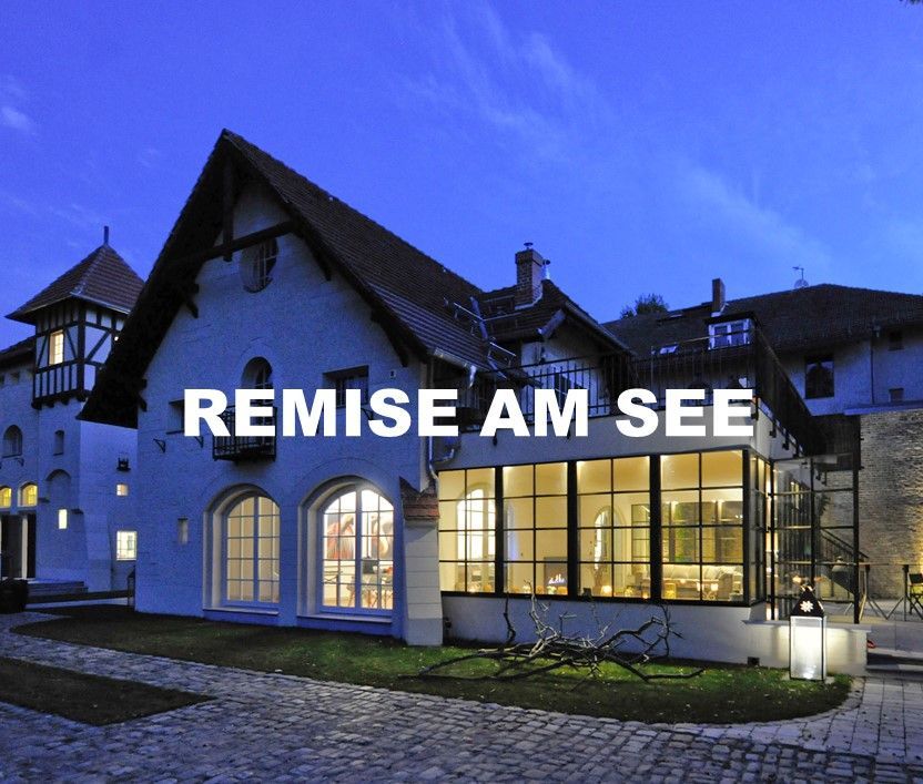 FLORIS Partner Location Remise Am See Capputh. Außenansicht auf Villa, im Inneren beleuchtet