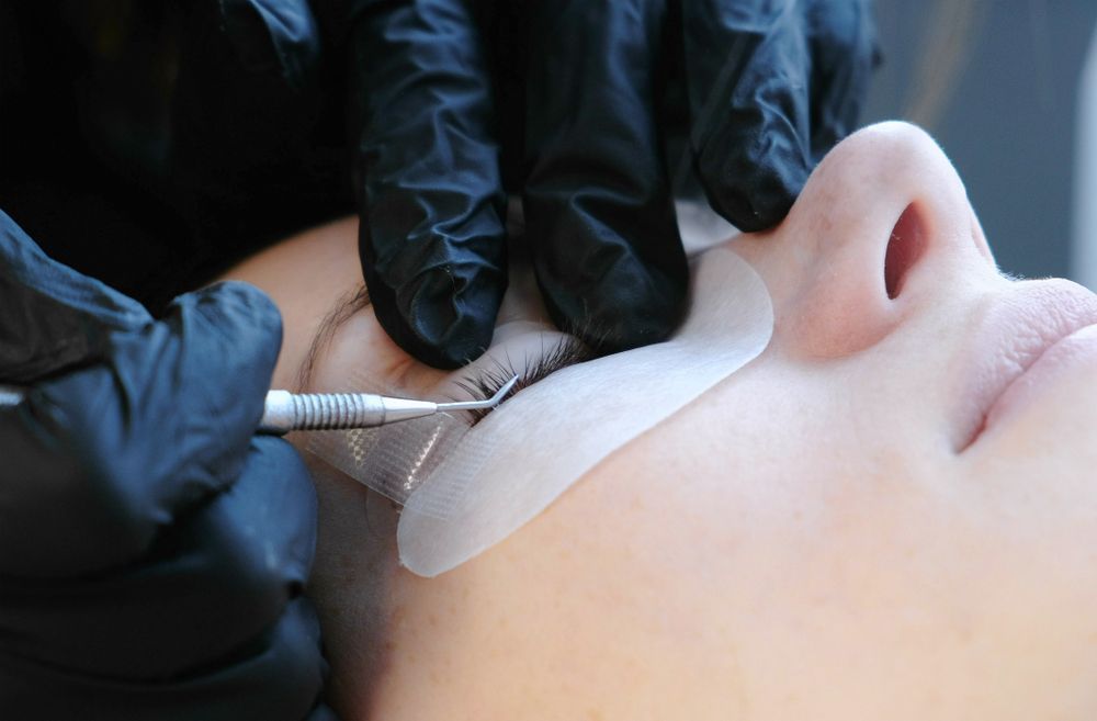 Gloved Hands Applying Eyelashes — Miilan Hair in Darwin City, NT