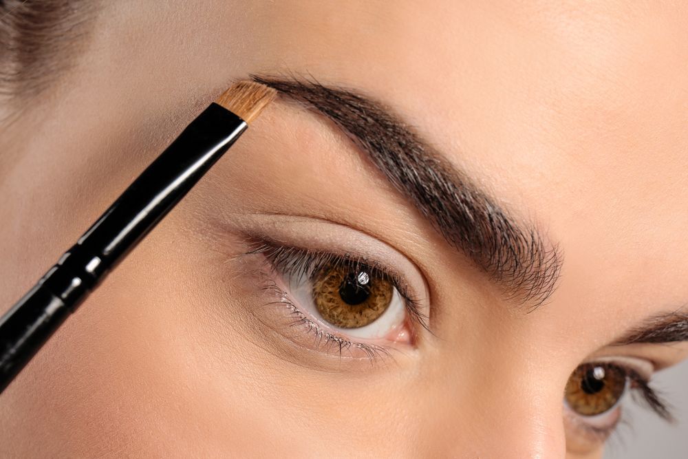 Eyebrow Being Shaped With a Brush Near a Woman's Eye, Close-up — Miilan Hair in Darwin City, NT