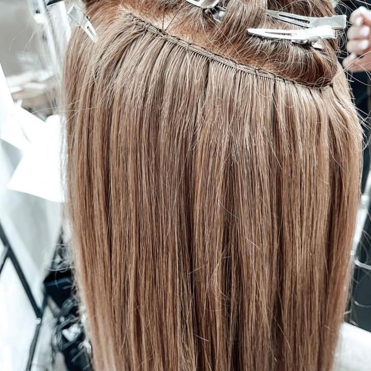 Stylist Sectioning Blonde Hair for Treatment Near a Salon Mirror — Miilan Hair in Darwin City, NT