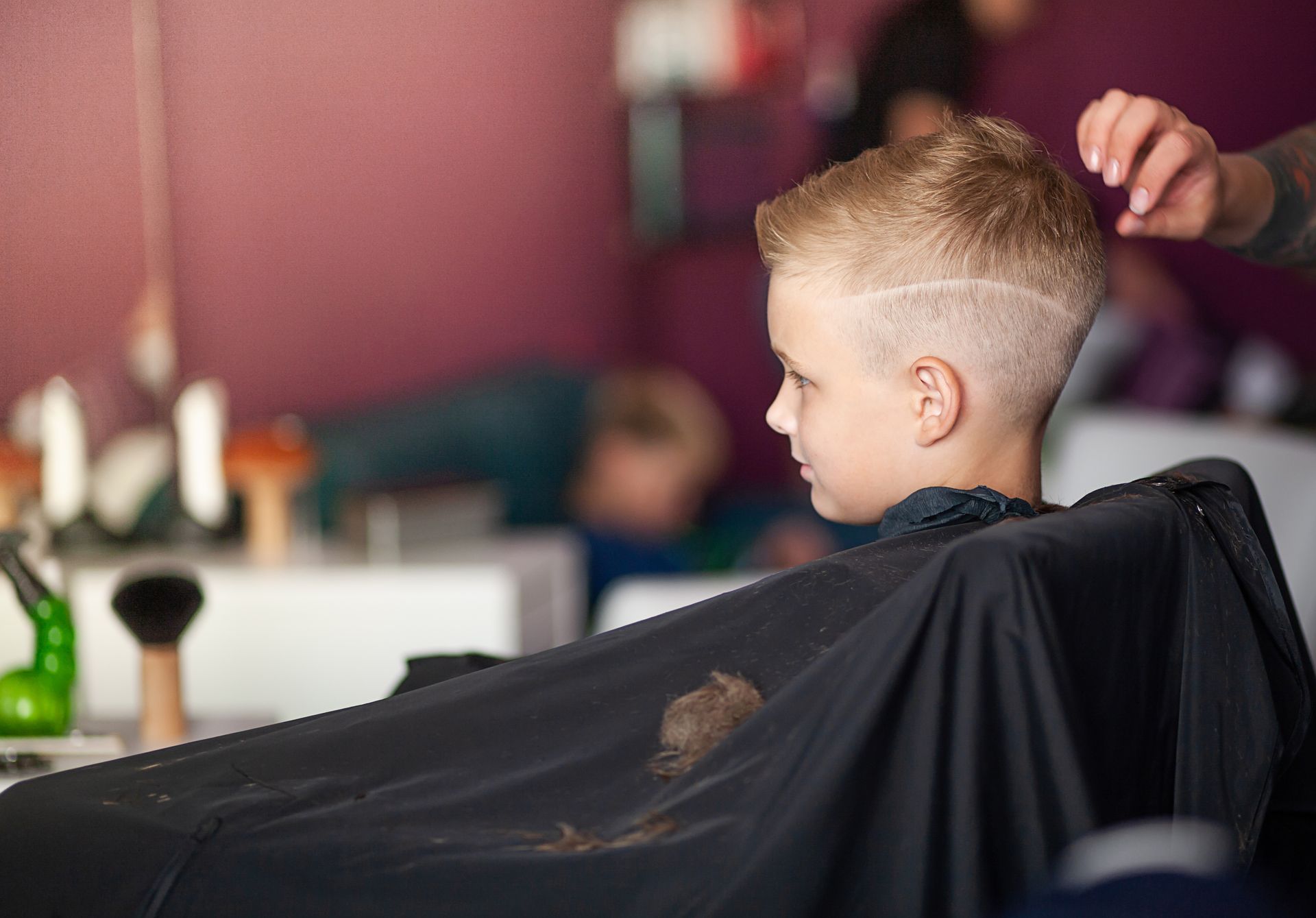 Young Child Getting a Haircut in a Barbershop, Wearing a Black Cape — Miilan Hair in Darwin City, NT