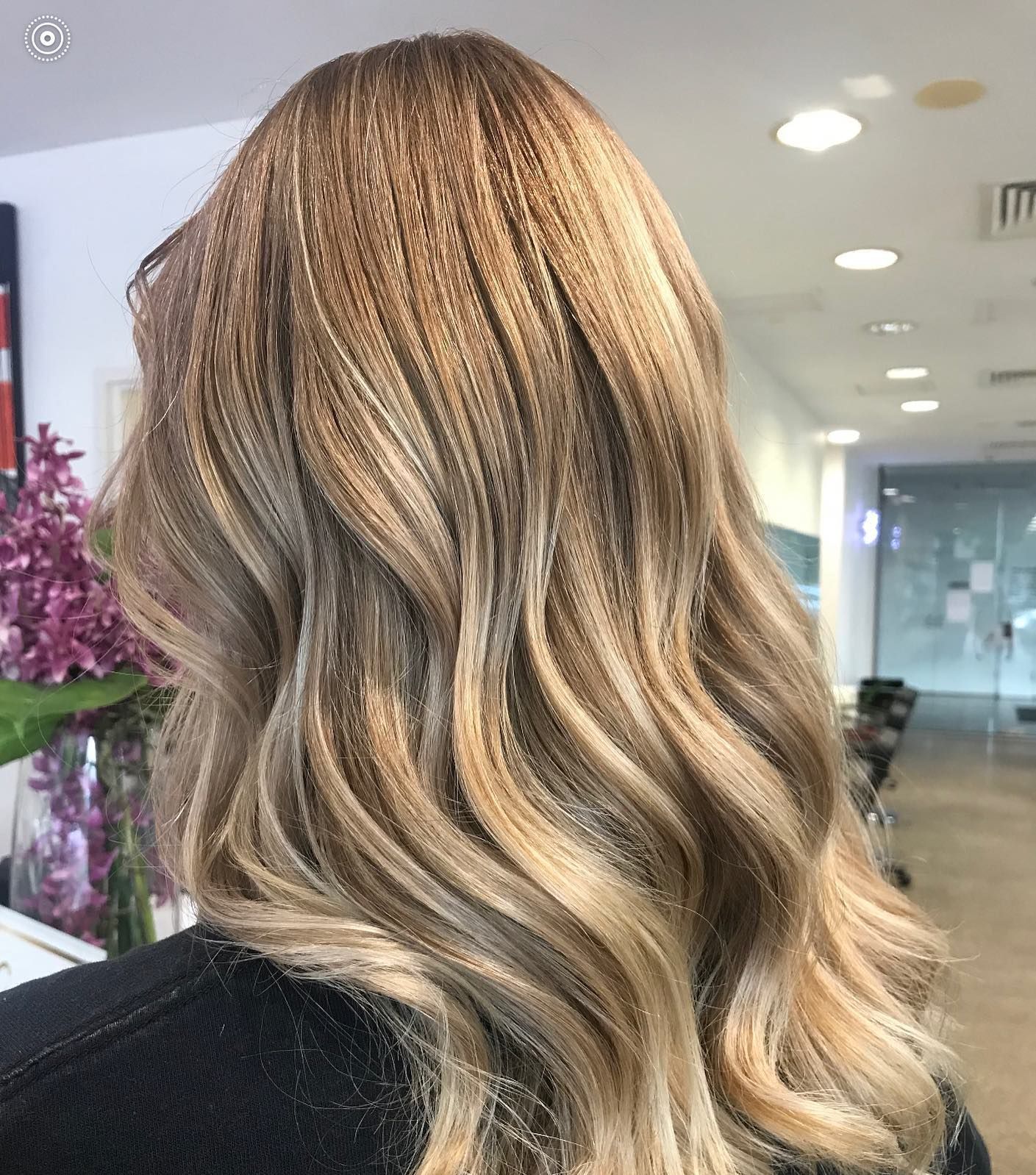 Wavy Blonde Balayage Hairstyle Shown From the Back in a Salon Setting — Miilan Hair in Darwin City, NT