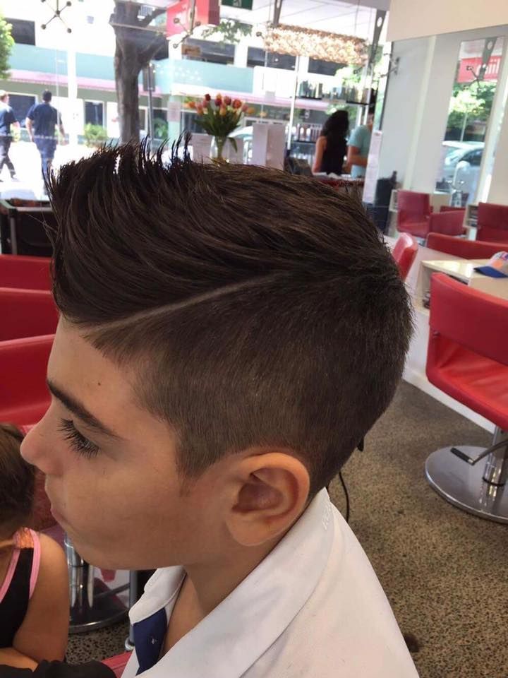 Profile View of a Boy With a Styled Haircut in a Bright Red-and-white Lounge Setting — Miilan Hair in Darwin City, NT