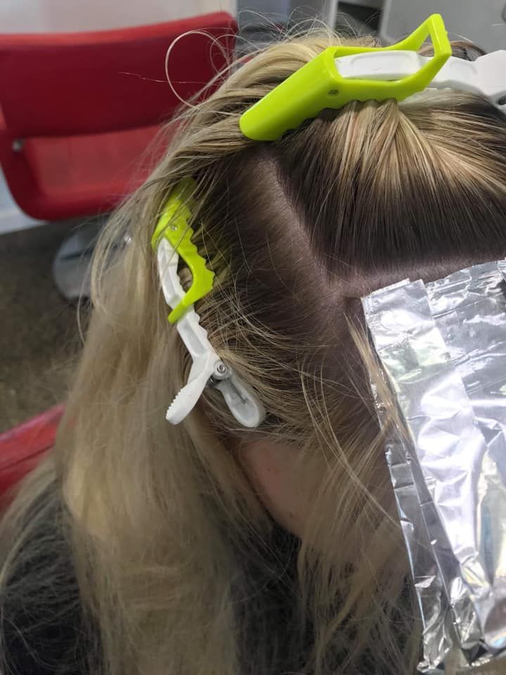 Hair Stylist Applying Foils to a Client’s Long Blonde Hair in a Salon — Miilan Hair in Darwin City, NT