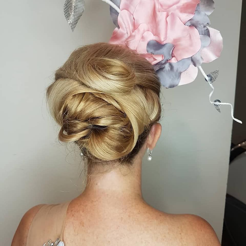 Elegant Blonde Updo With Floral Hair Accessory, Viewed From the Back on a Woman — Miilan Hair in Darwin City, NT