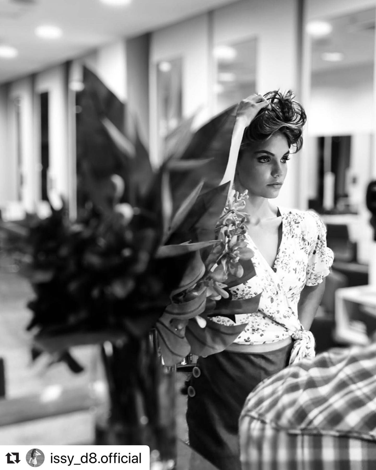 Woman in a Floral Dress Posing Indoors With Plants and Salon Chairs — Miilan Hair in Darwin City, NT