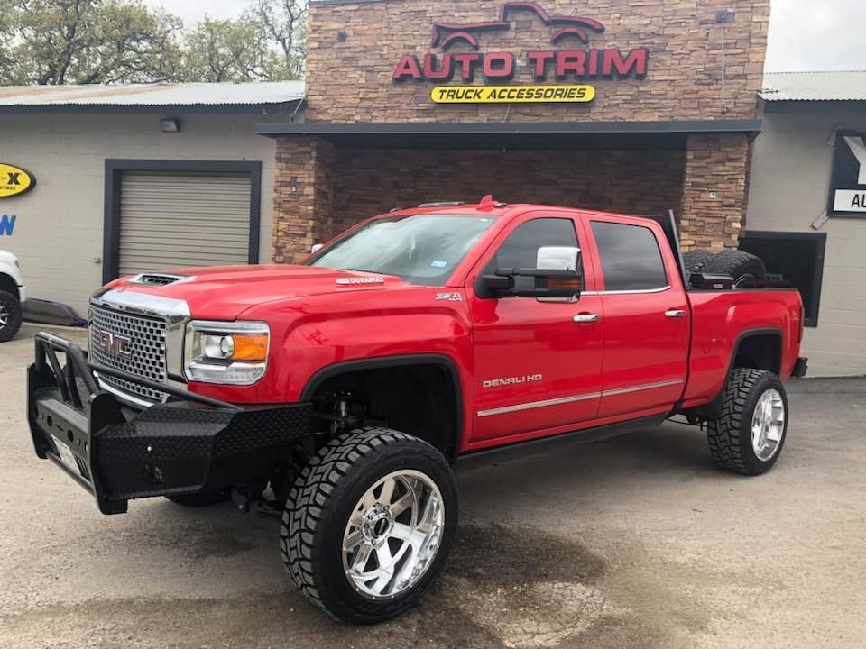 A red pickup truck is parked in front of a building.