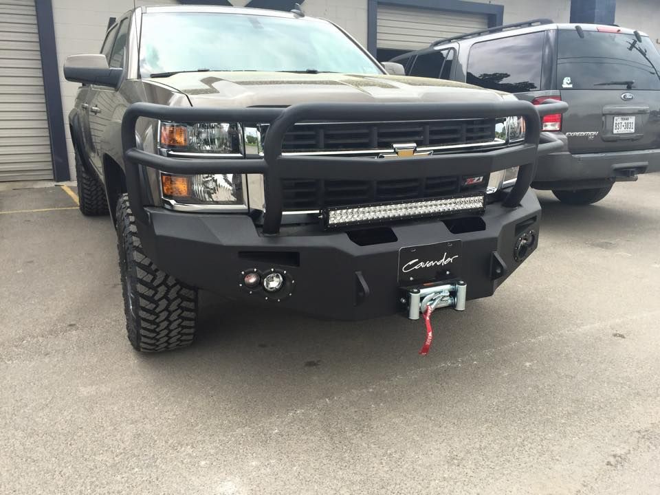 A black truck with a winch attached to the front bumper