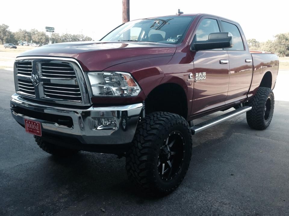 A red dodge ram truck is parked in a parking lot.