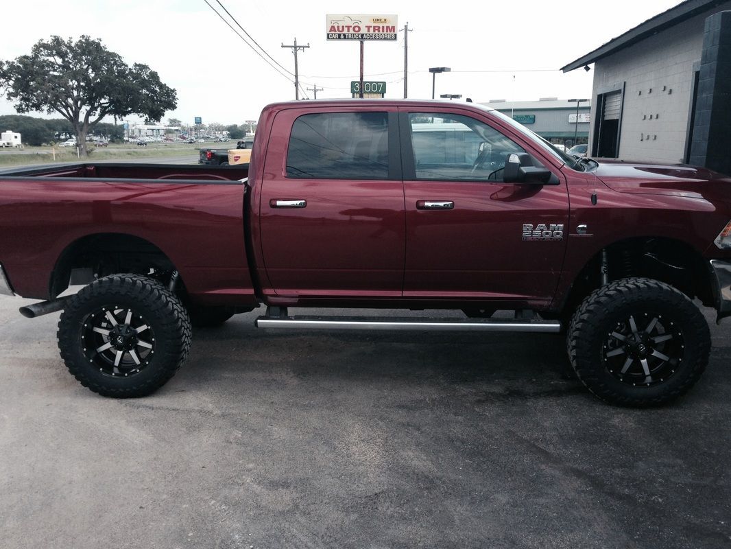 A red ram truck is parked in front of a building
