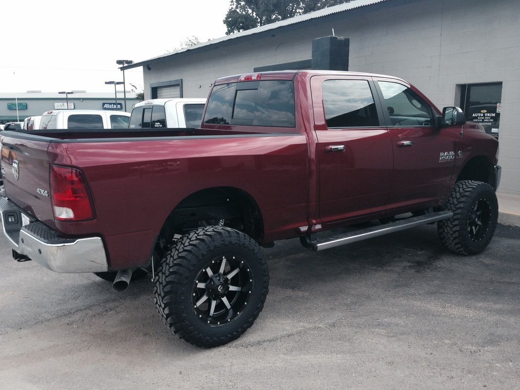 A red truck is parked in front of a building.