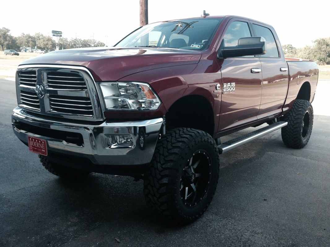 A red dodge ram truck is parked in a parking lot.