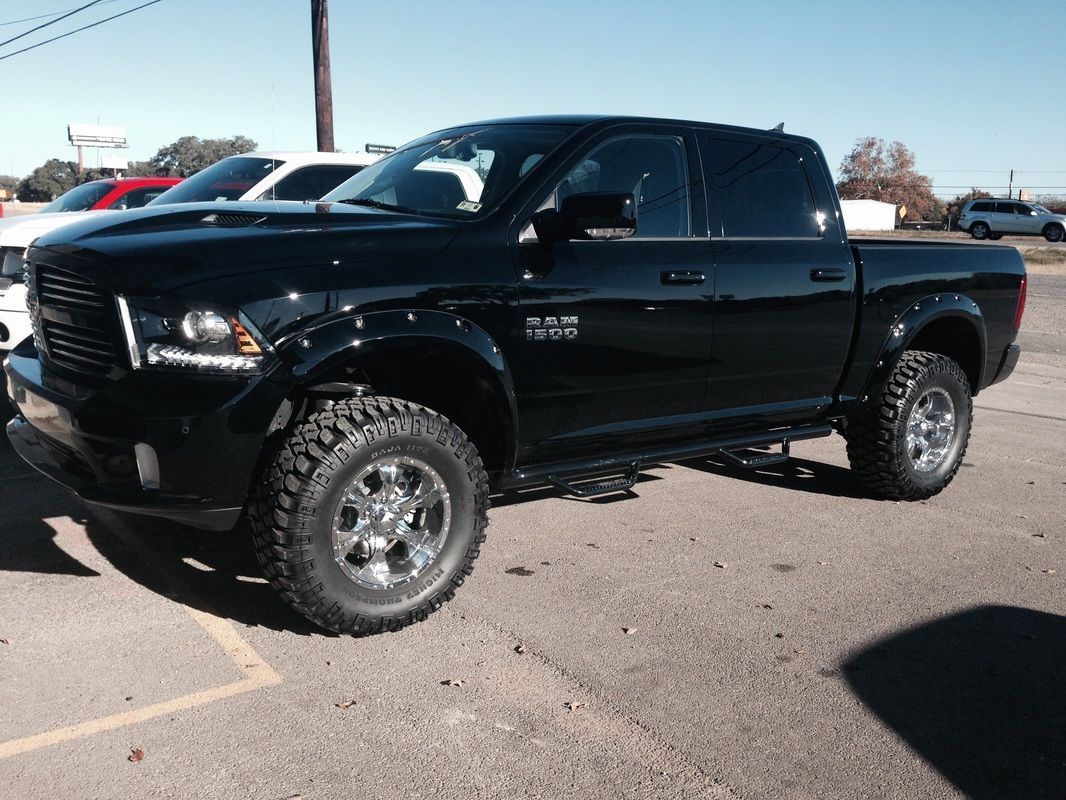 A black dodge ram truck is parked in a parking lot
