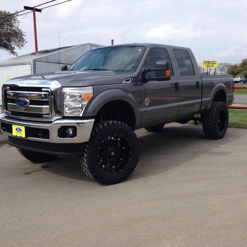 A gray ford truck is parked in a parking lot